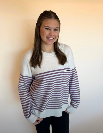 Person wearing a striped sweater against a plain background