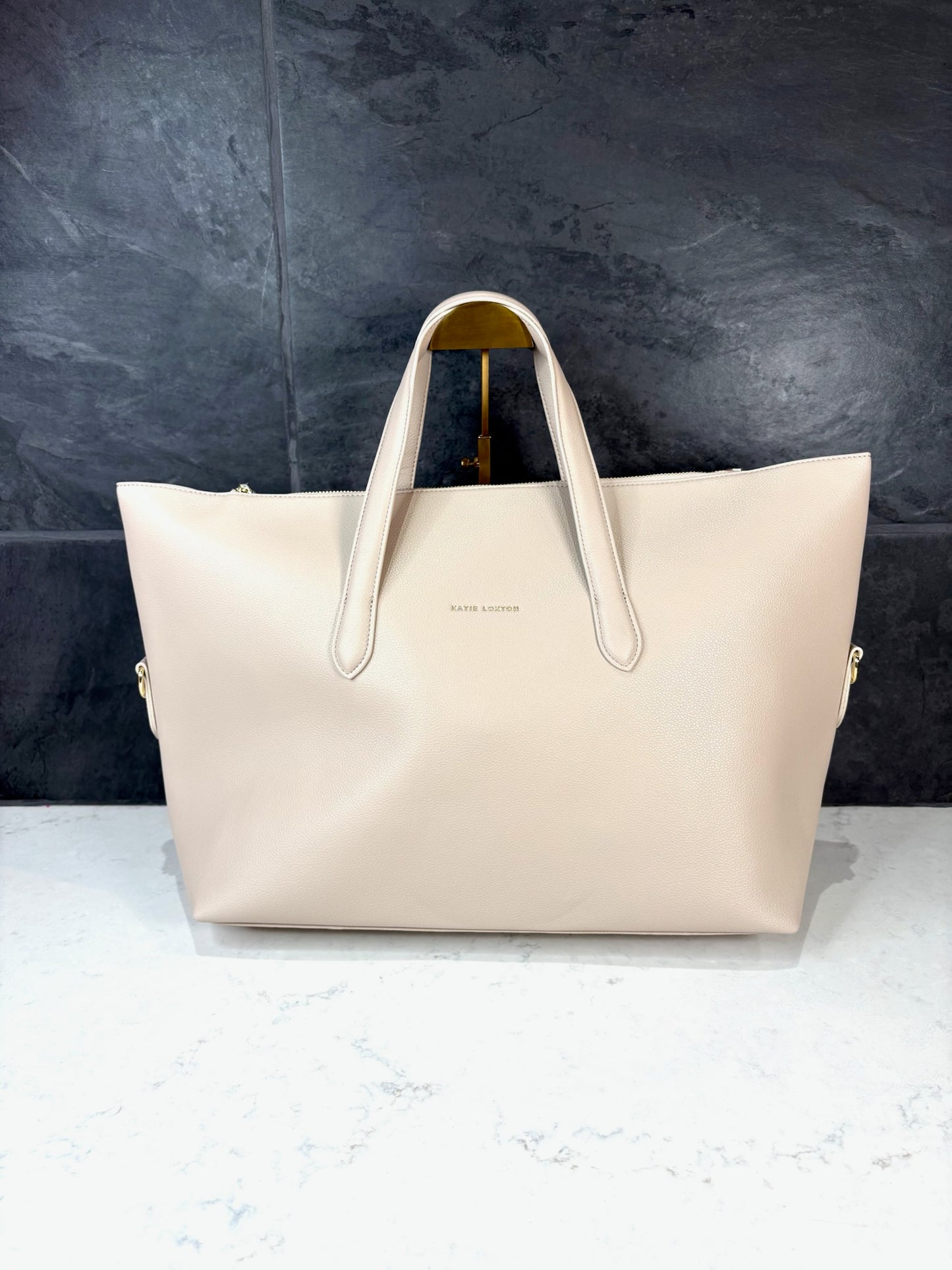 Milan Cabin Bag in Oyster by Katie Loxton, oversized vegan leather travel tote with top handles and gold hardware.