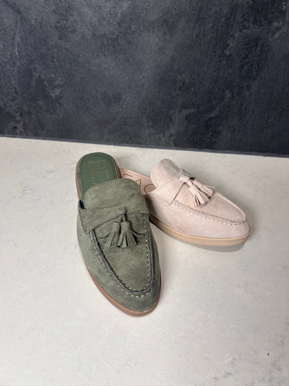 Green and pink loafers on a gray surface with a dark background