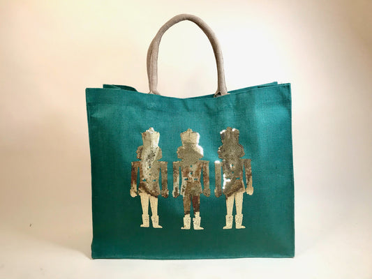 Oversized Christmas carryall tote featuring trio of gold nutcracker figures on emerald green background