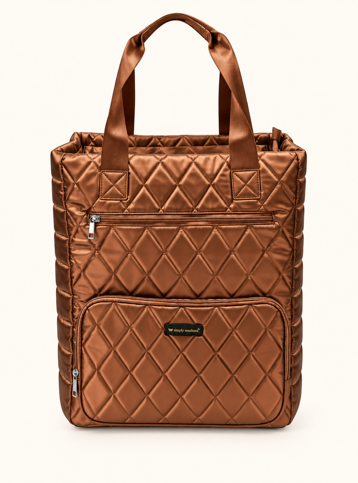 Simply Southern copper quilted travel tote bag with metallic finish, padded carrying handles, diamond stitching, and two front zippered pockets.