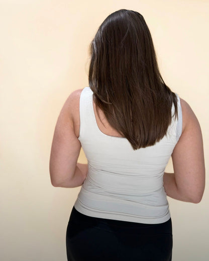 Back view of a pearl white tank top on a woman with long brown hair, showing the fit and scoop back design.
