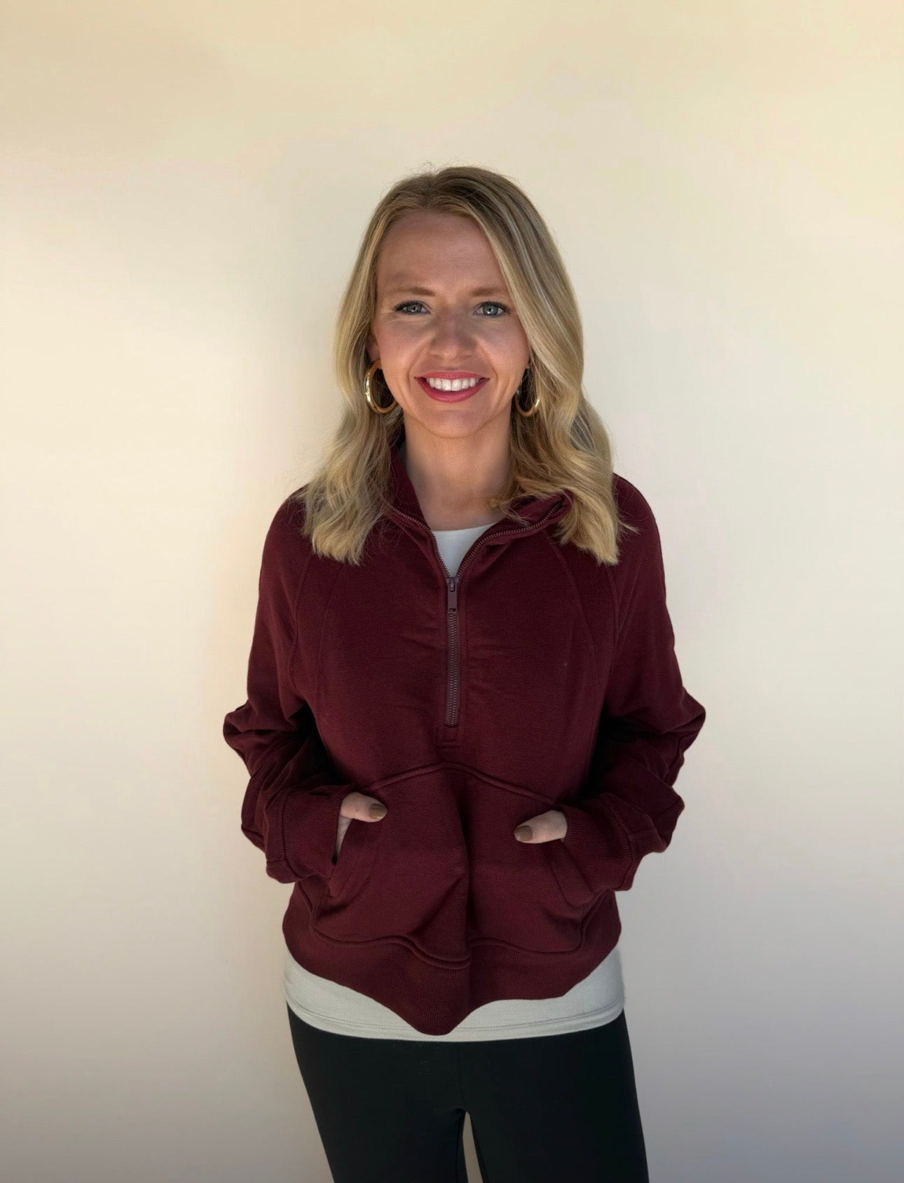 Woman wearing a burgundy jacket against a plain background