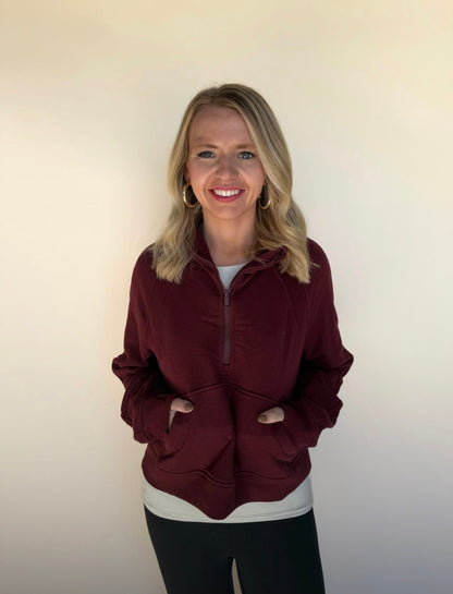 Woman wearing a burgundy jacket against a plain background