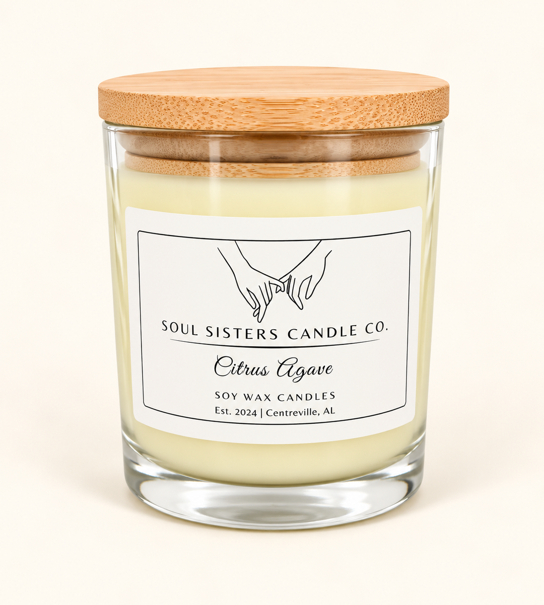 Soul Sisters Candle Co. Citrus Agave soy wax candle featuring pale ivory wax, clear glass jar, natural bamboo lid, and white branded label on a cream background.