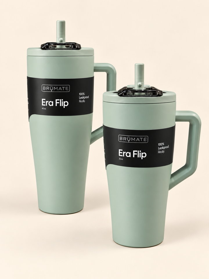 BrüMate Era Flip insulated tumblers in soft sage green, featuring 40oz and 30oz sizes with matching handles, leakproof flip straw lids, and black branded labels on a cream studio background.