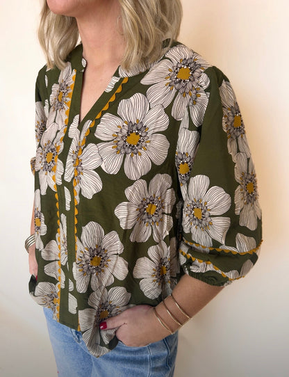 Person wearing a floral blouse with green background