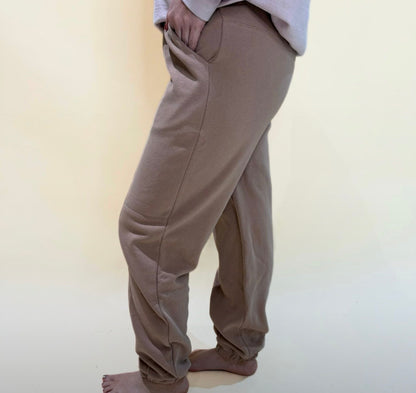 Side view of taupe jogger pants featuring pockets, soft stretch fabric, and a loose comfortable silhouette.