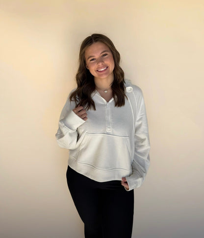 Person wearing an off white hoodie against a plain background