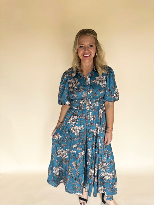 Woman wearing a blue floral dress against a beige background