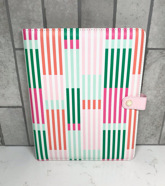 Colorful striped patterned notebook on a gray tiled background