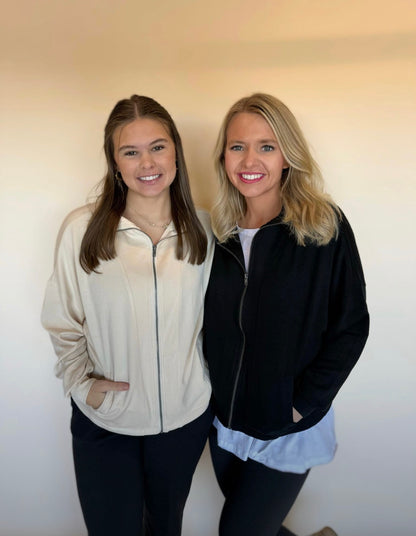 Two women standing side by side against a plain background