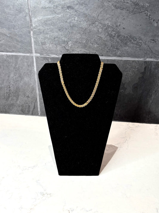 Katie Loxton braid chain gold coated necklace displayed on black jewelry stand, waterproof 18k gold PVD braided chain necklace.