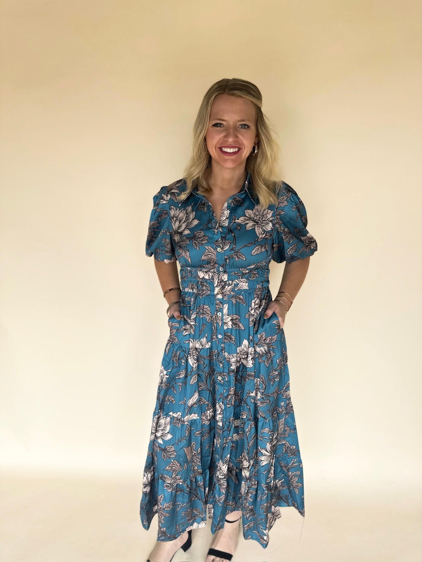 Woman wearing a blue floral dress against a plain background
