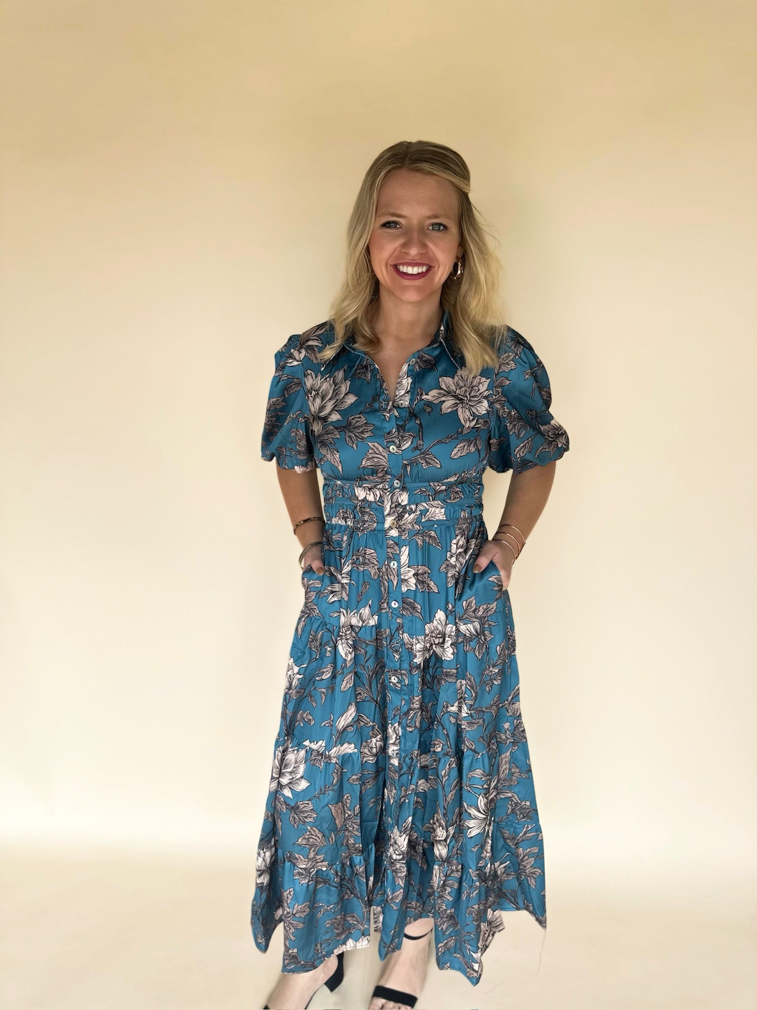 Woman wearing a blue floral dress against a plain background