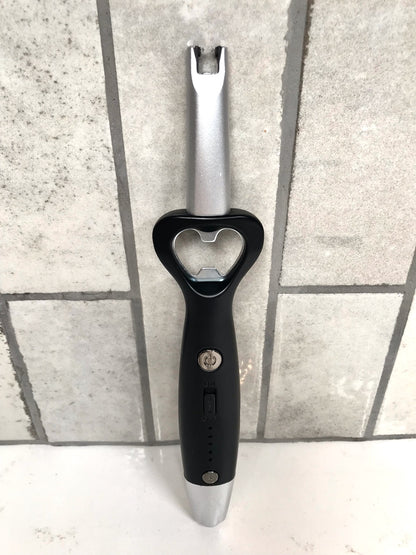 Black and silver bottle opener on a tiled floor
