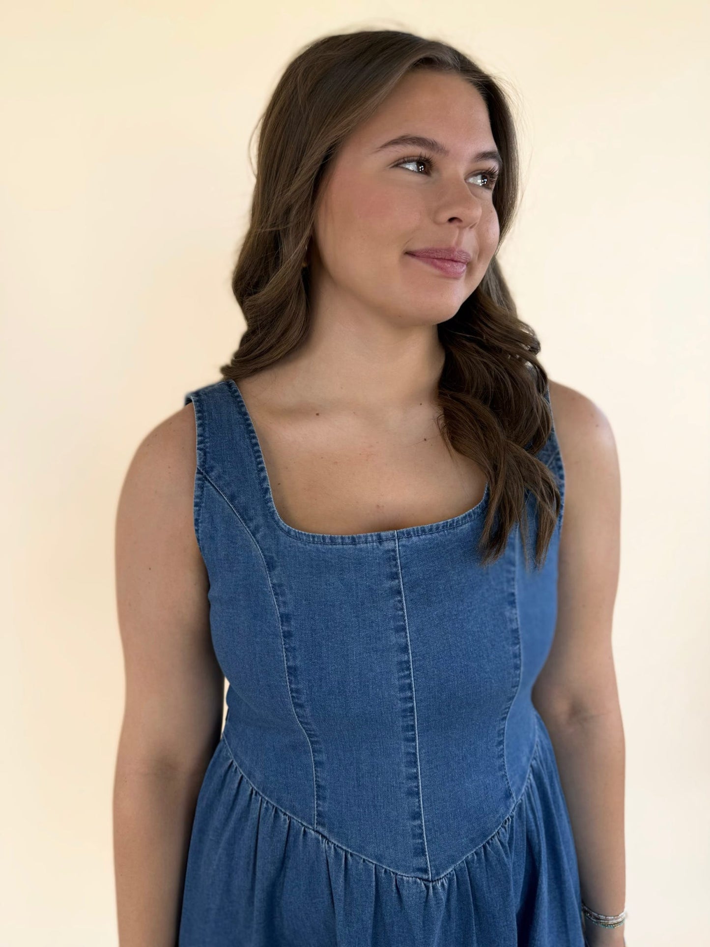 Close-up of baby blue denim dress with structured bodice and scoop neckline detail