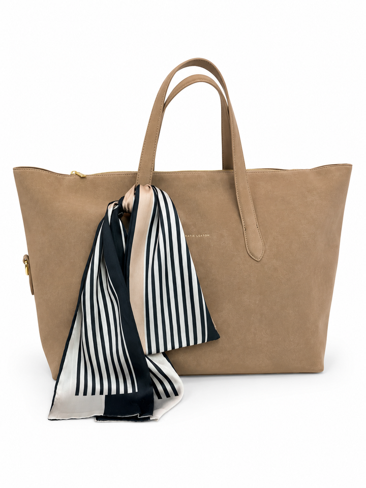 Tan Katie Loxton tote bag styled with a black, ivory, and beige striped scarf on a clean white background.