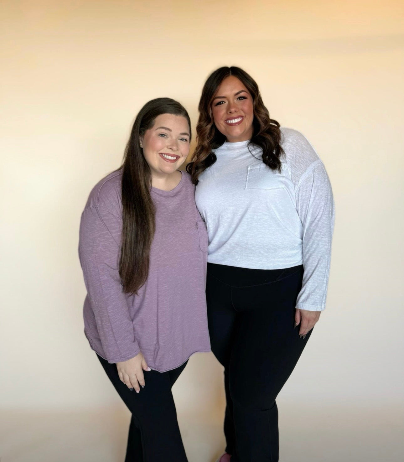 Two women standing side by side against a plain background
