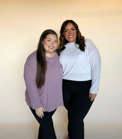 Two women standing side by side against a plain background