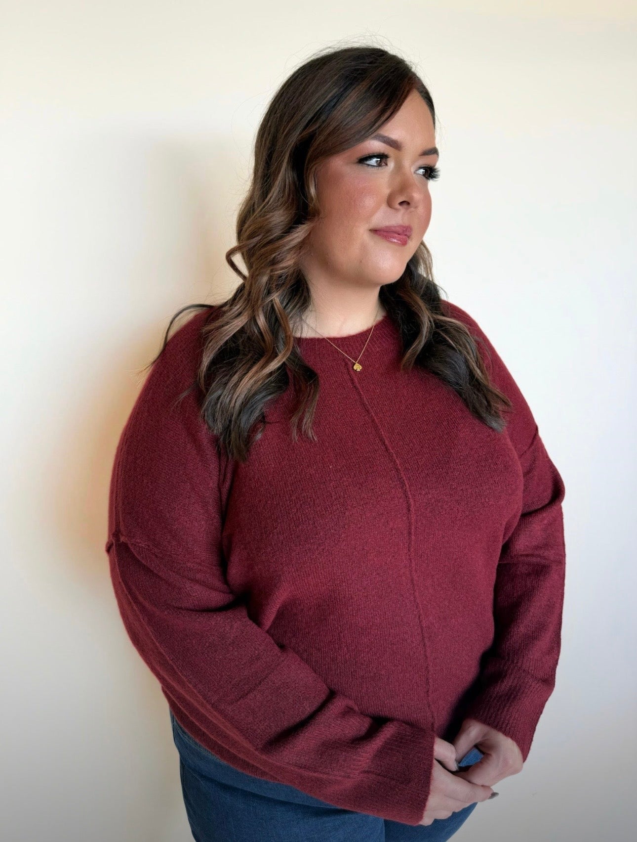 Woman wearing a maroon sweater against a plain background