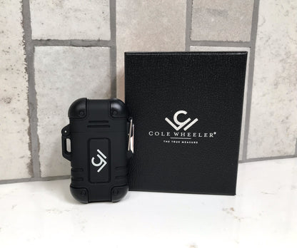 Black case with Cole Wheeler logo next to a black box with the same logo on a stone wall background