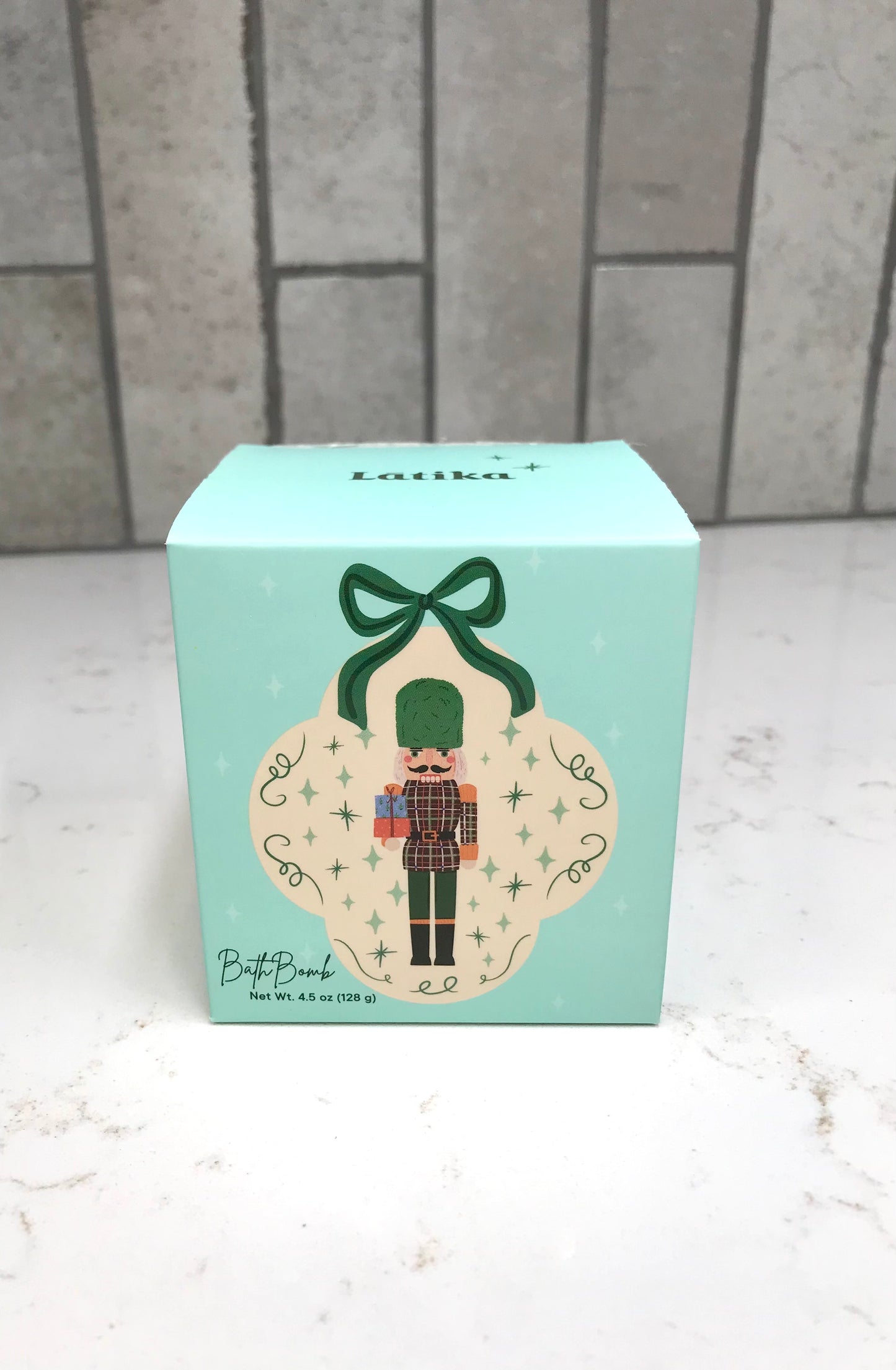 Light blue box with a decorative design featuring a nutcracker on a white surface with a tiled wall background.