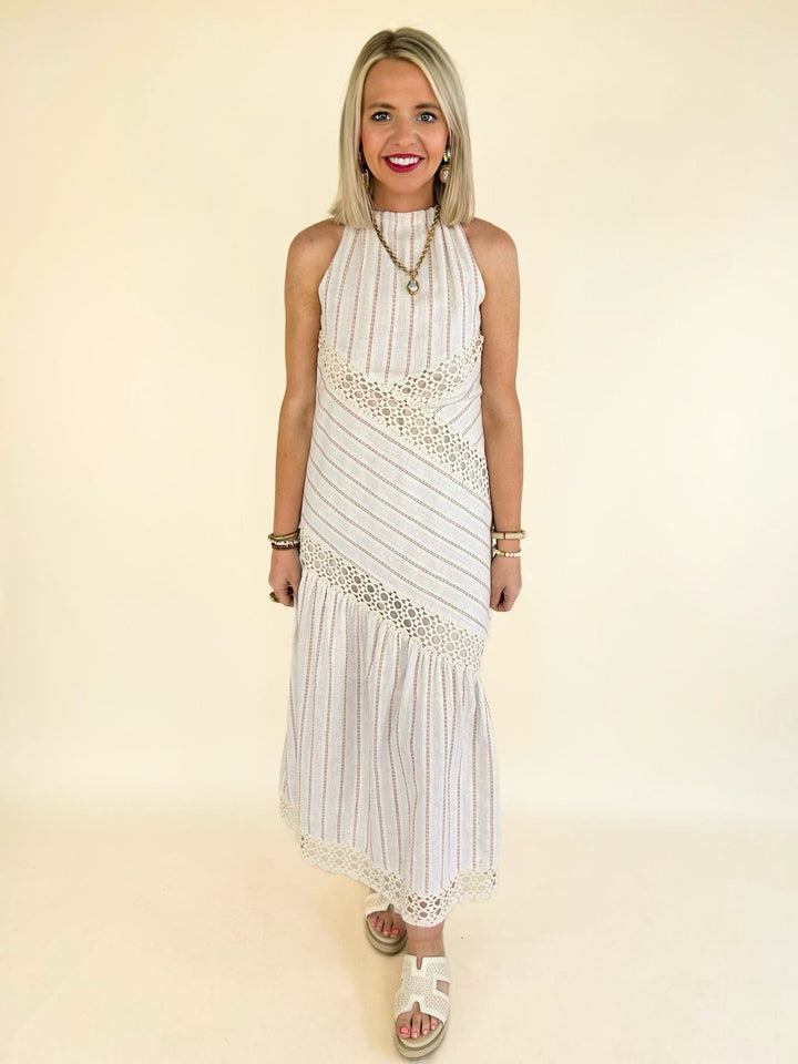 Woman wearing the Bella Halter Cutout Tiered Maxi Dress featuring a halter neckline, crochet lace accents, subtle cutout detail, and a flowy tiered skirt.