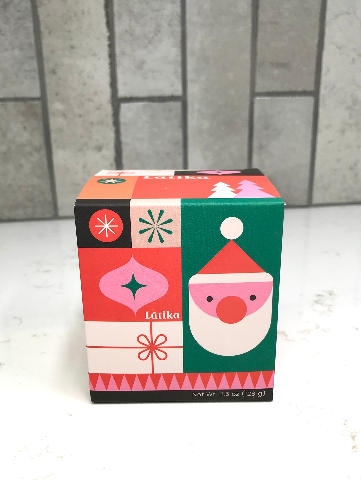 Colorful box with a Santa Claus design on a tiled floor background