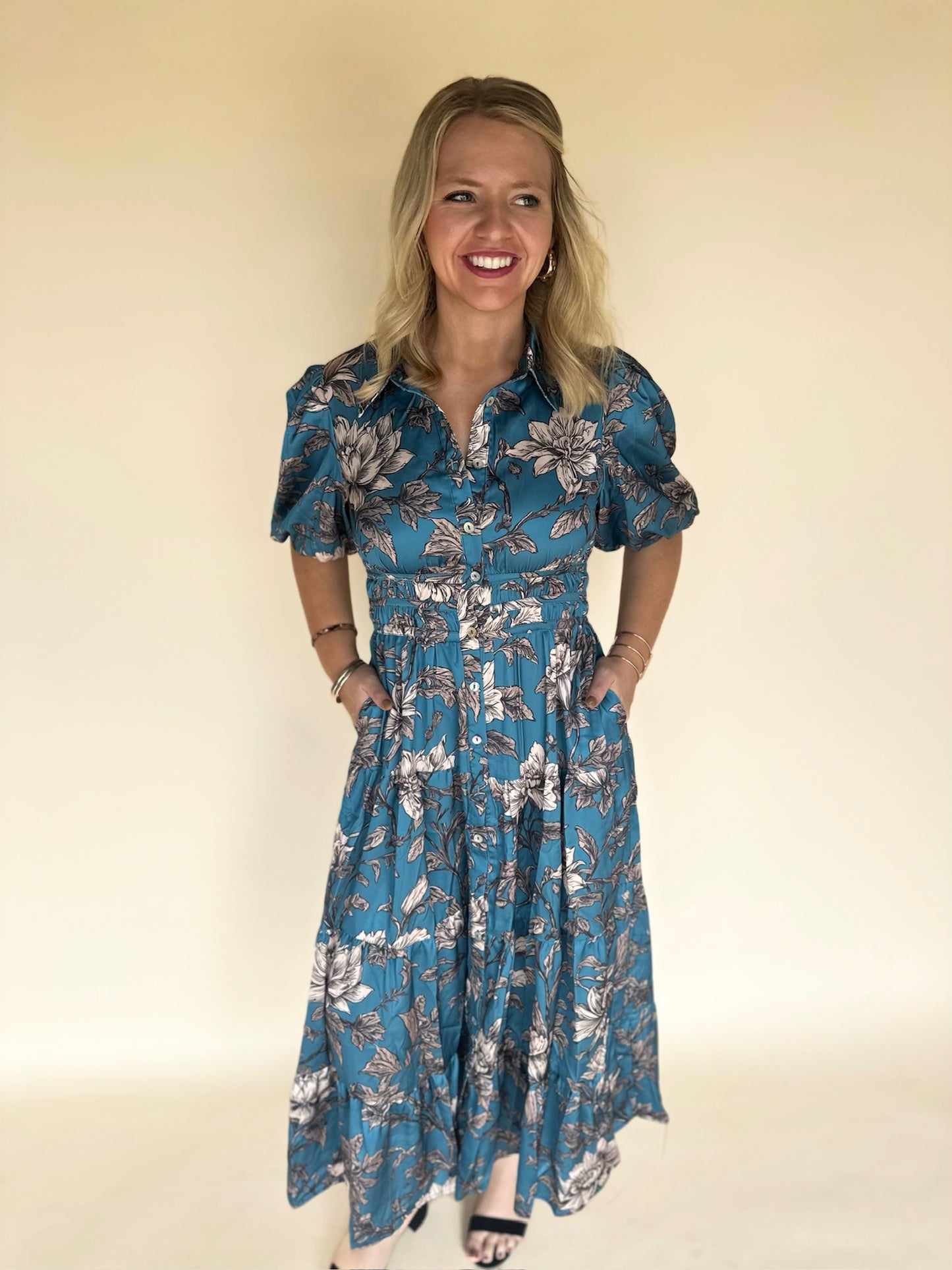 Woman wearing a blue floral dress against a beige background