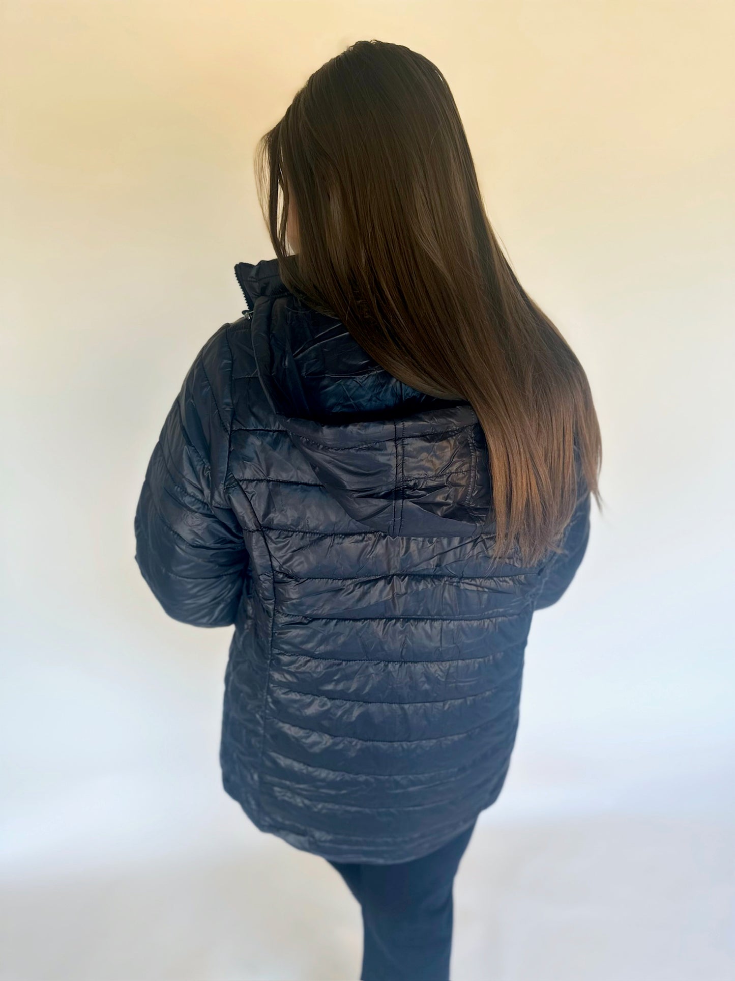 Person wearing a blue puffer jacket against a white background