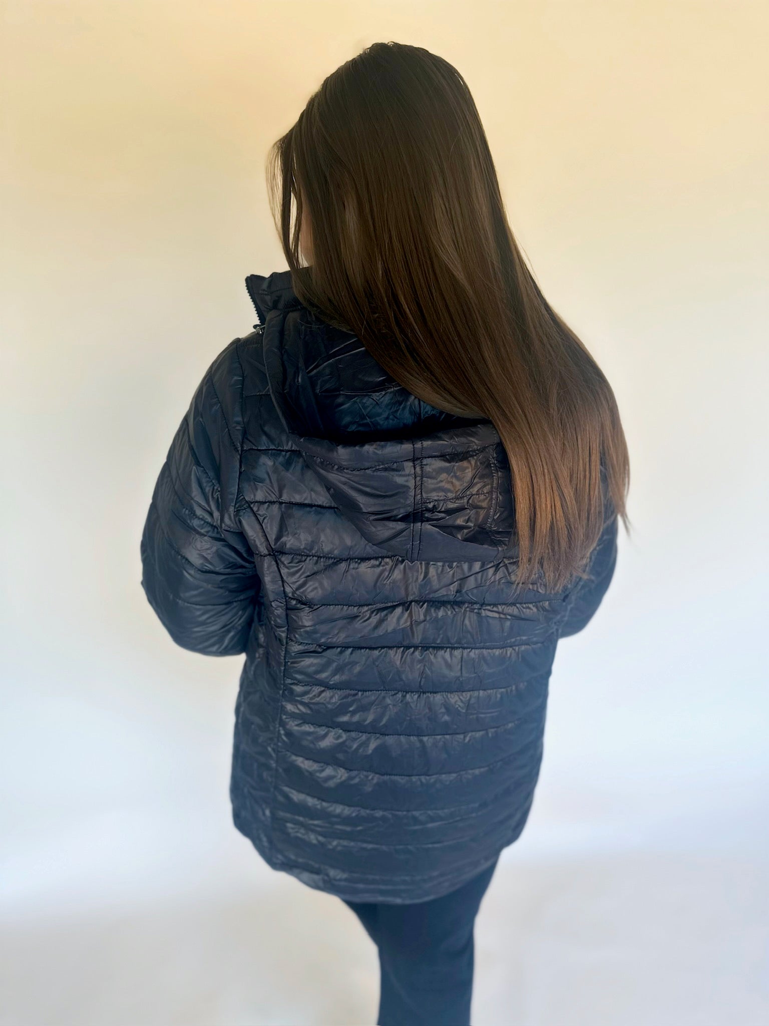 Person wearing a blue puffer jacket against a white background