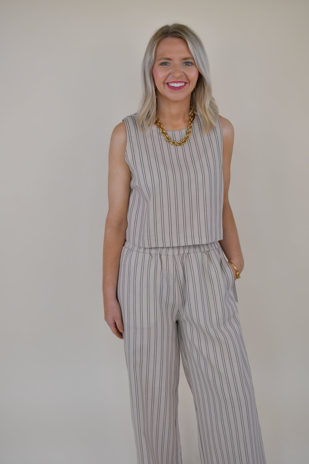 Women's sleeveless beige pinstripe linen blend top with a relaxed fit, crew neckline, and coordinating wide leg pants.