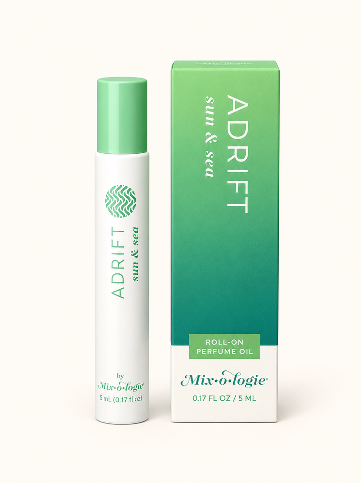 Mixologie Adrift Sun &amp; Sea 5 mL rollerball perfume oil with mint green cap and green gradient fragrance box on a cream background.