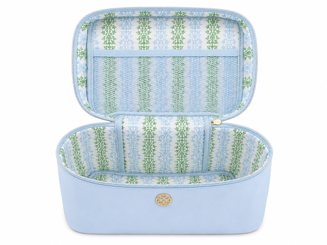 Open sky blue travel cosmetic case with spacious compartment, mesh zip pocket, patterned interior lining, and wide-opening design for organizing makeup, skincare, toiletries, an