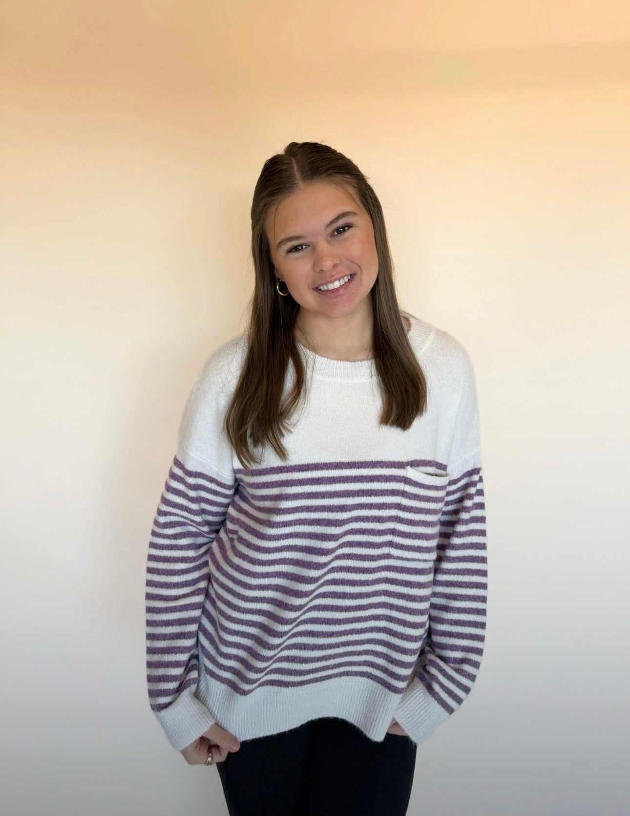 Person wearing a striped sweater against a plain background