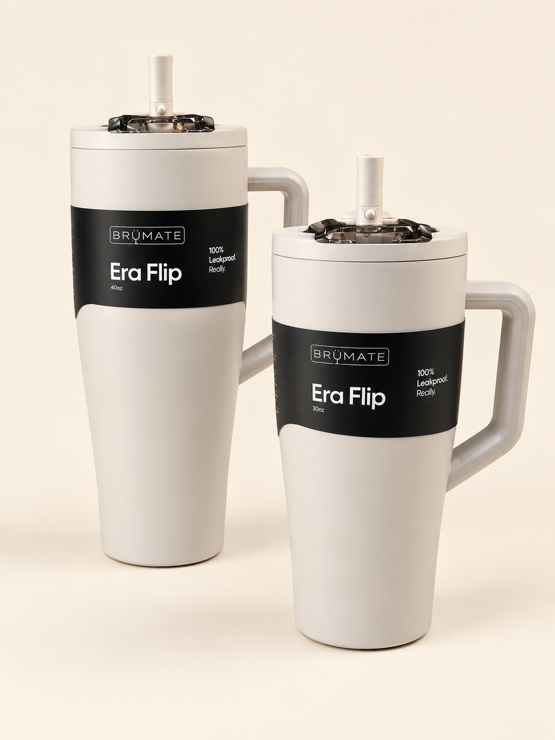 BrüMate Era Flip insulated tumblers in light neutral cream, featuring 40oz and 30oz sizes with matching handles, flip straws, leakproof lids, and black branded labels on a cream studio background.