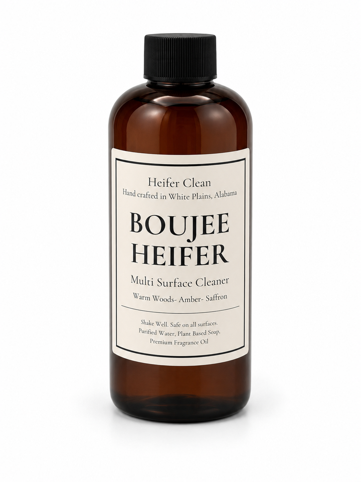 Heifer Clean Boujee Heifer multi surface cleaner in an amber bottle with warm woods, amber, and saffron fragrance for everyday household cleaning.