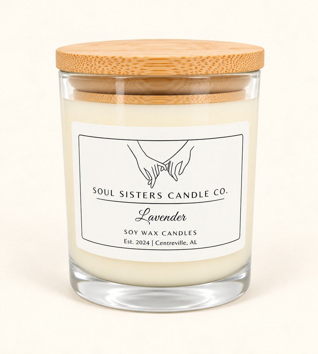 Soul Sisters Candle Co. Lavender scented soy wax candle in a clear glass jar with creamy white wax, natural bamboo lid, and minimalist white label on a cream studio background.