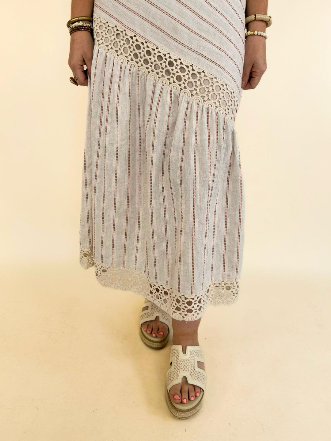 Lower front view of the Bella Halter Cutout Tiered Maxi Dress featuring the flowing tiered skirt, crochet lace hem, and boho-inspired design.