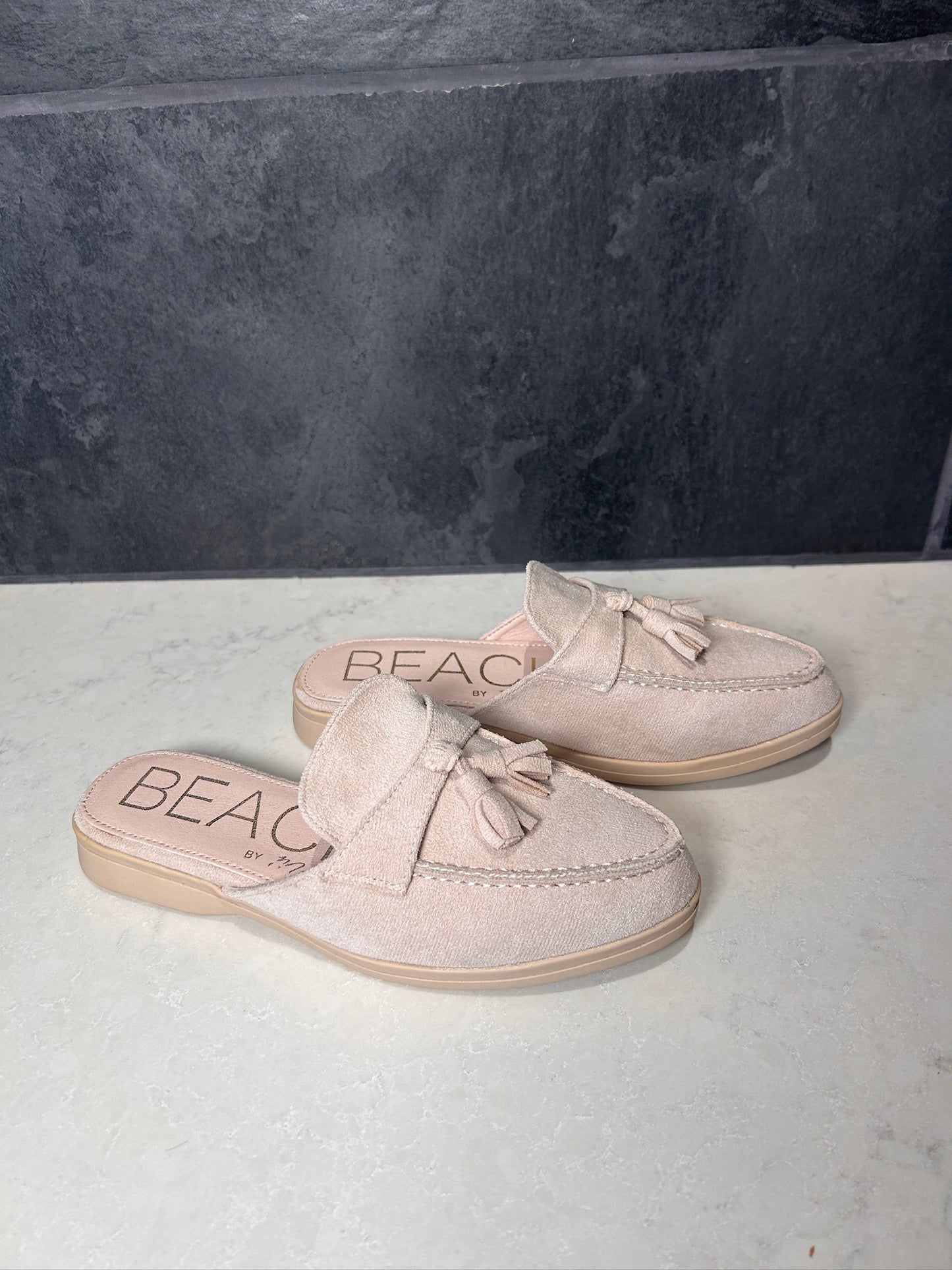 Pair of beige loafers with 'BEAC' branding on a light gray surface.