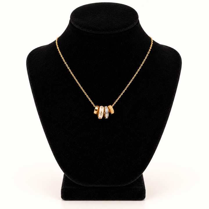 Jane Marie 16-inch gold cable chain necklace with petite 0.5-inch crystal and white rondelle pendant cluster displayed on a black velvet necklace bust against a cream background.