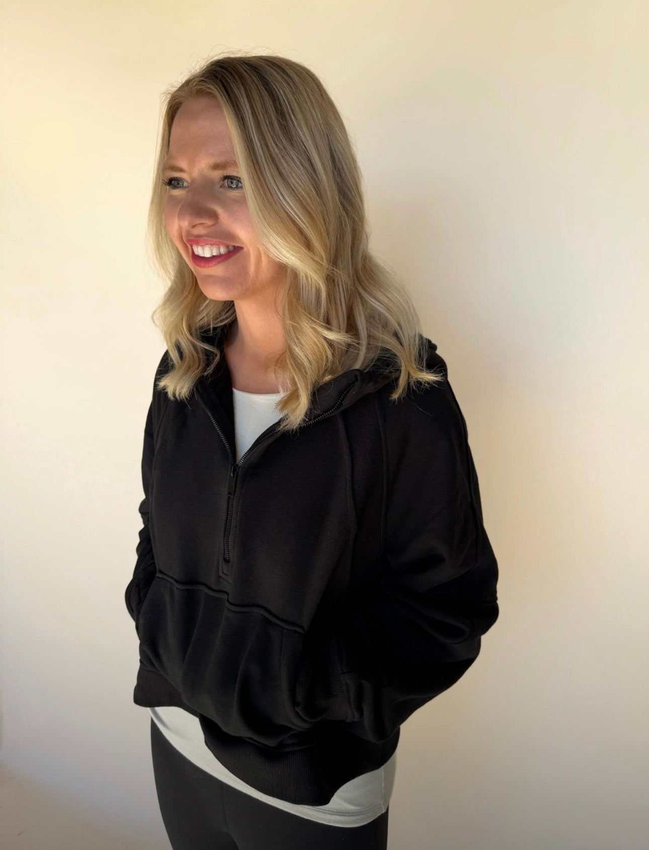 Person wearing a black hoodie against a plain background