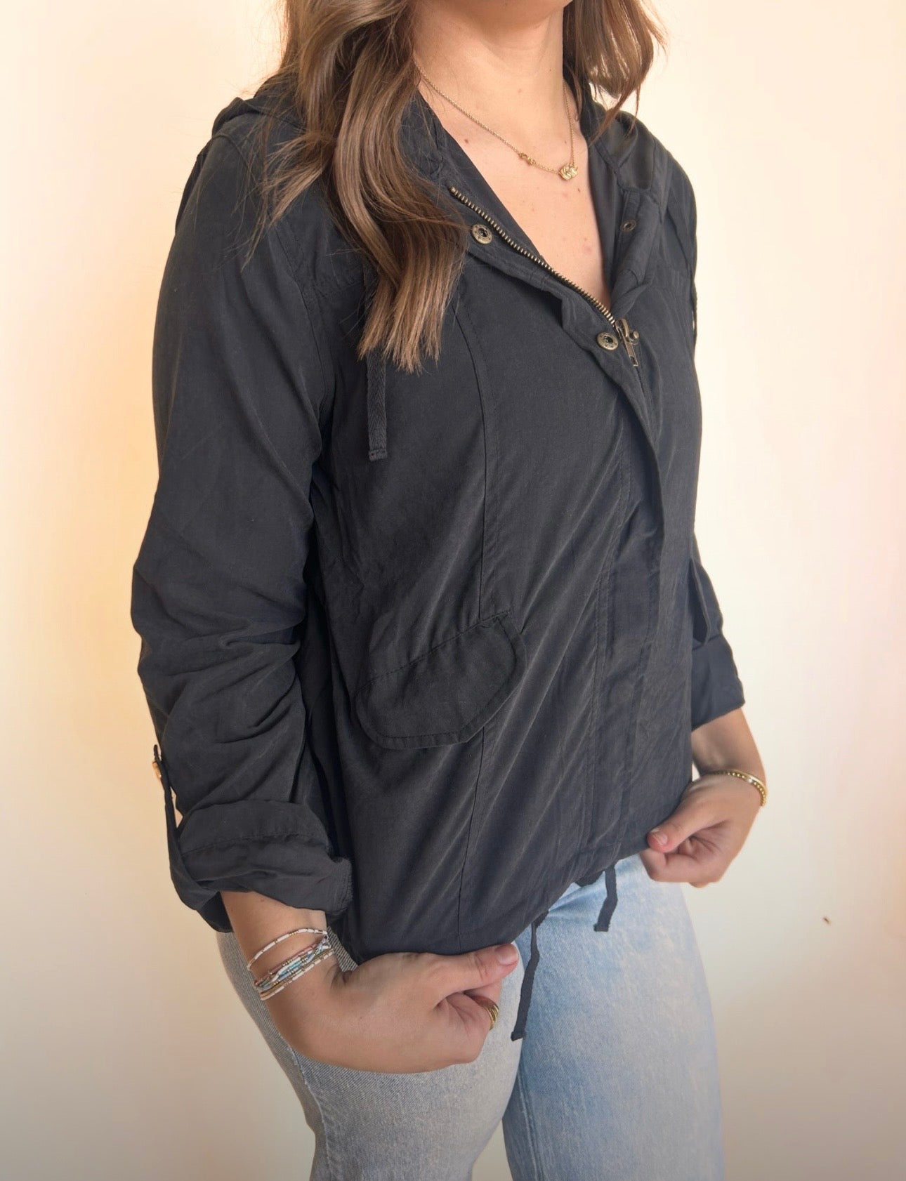 Person wearing a black jacket with a neutral background