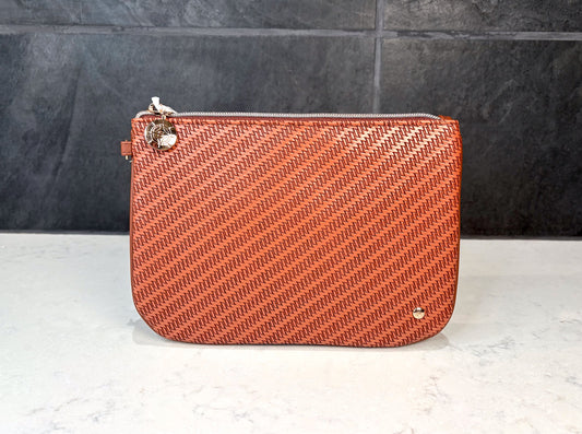 Stephanie Johnson Aria large flat pouch in cognac woven texture with zip closure, designed for organizing makeup, toiletries, and travel essentials.
