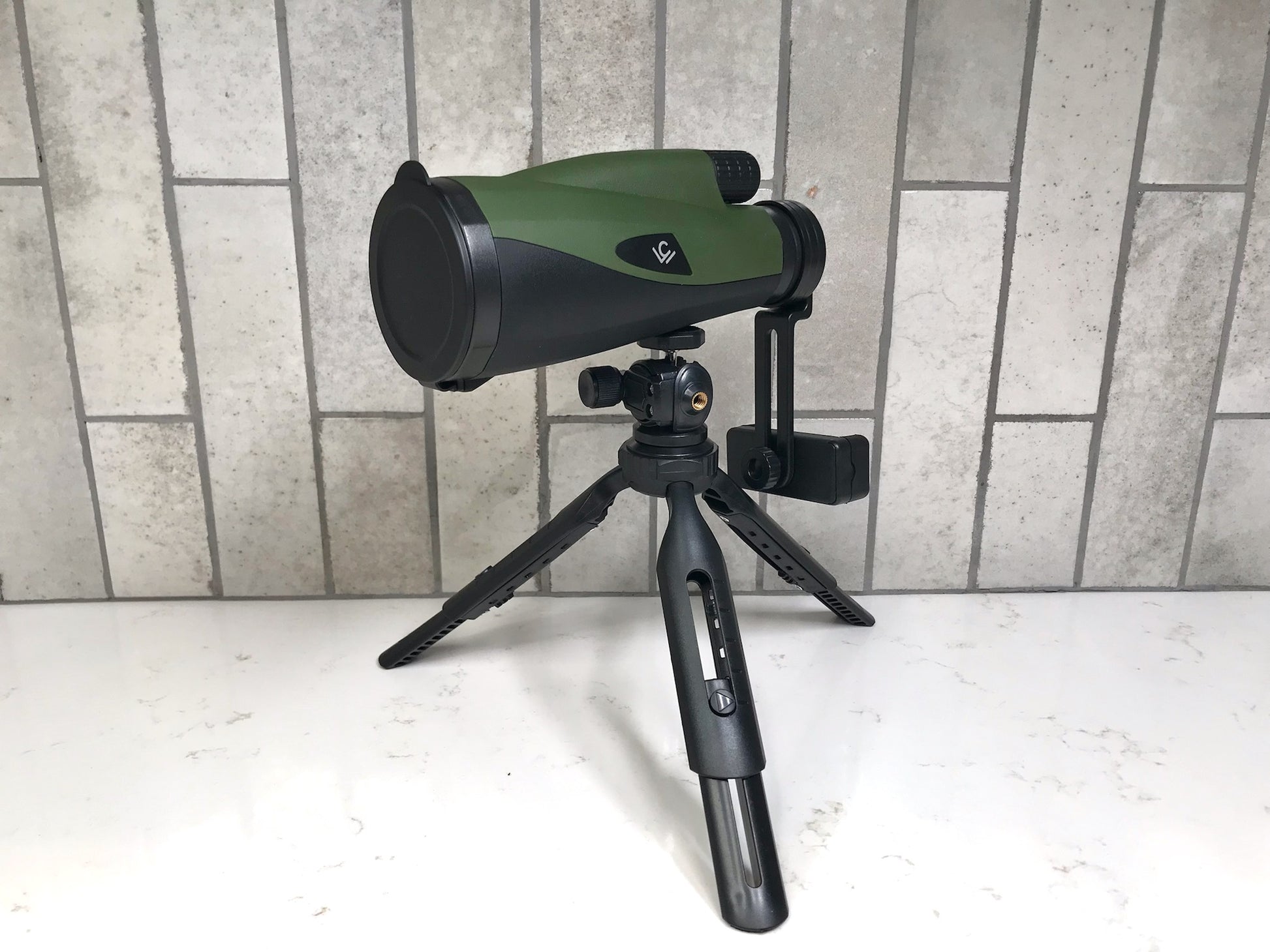 Telescope on a tripod against a tiled wall background Cole Wheeler