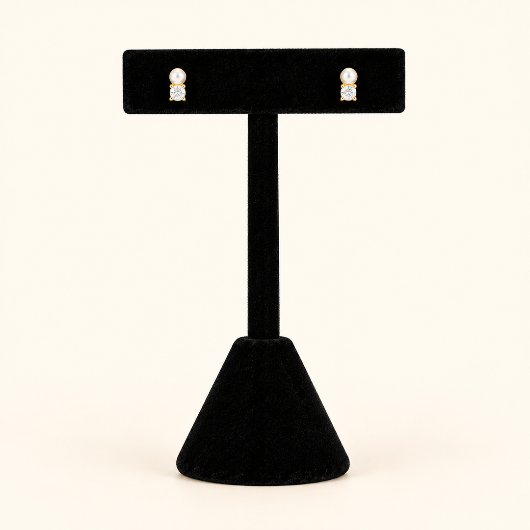 Petite 0.25-inch pearl and crystal stud earrings with gold-tone accents displayed on a tall black velvet T-bar jewelry stand against a cream background.