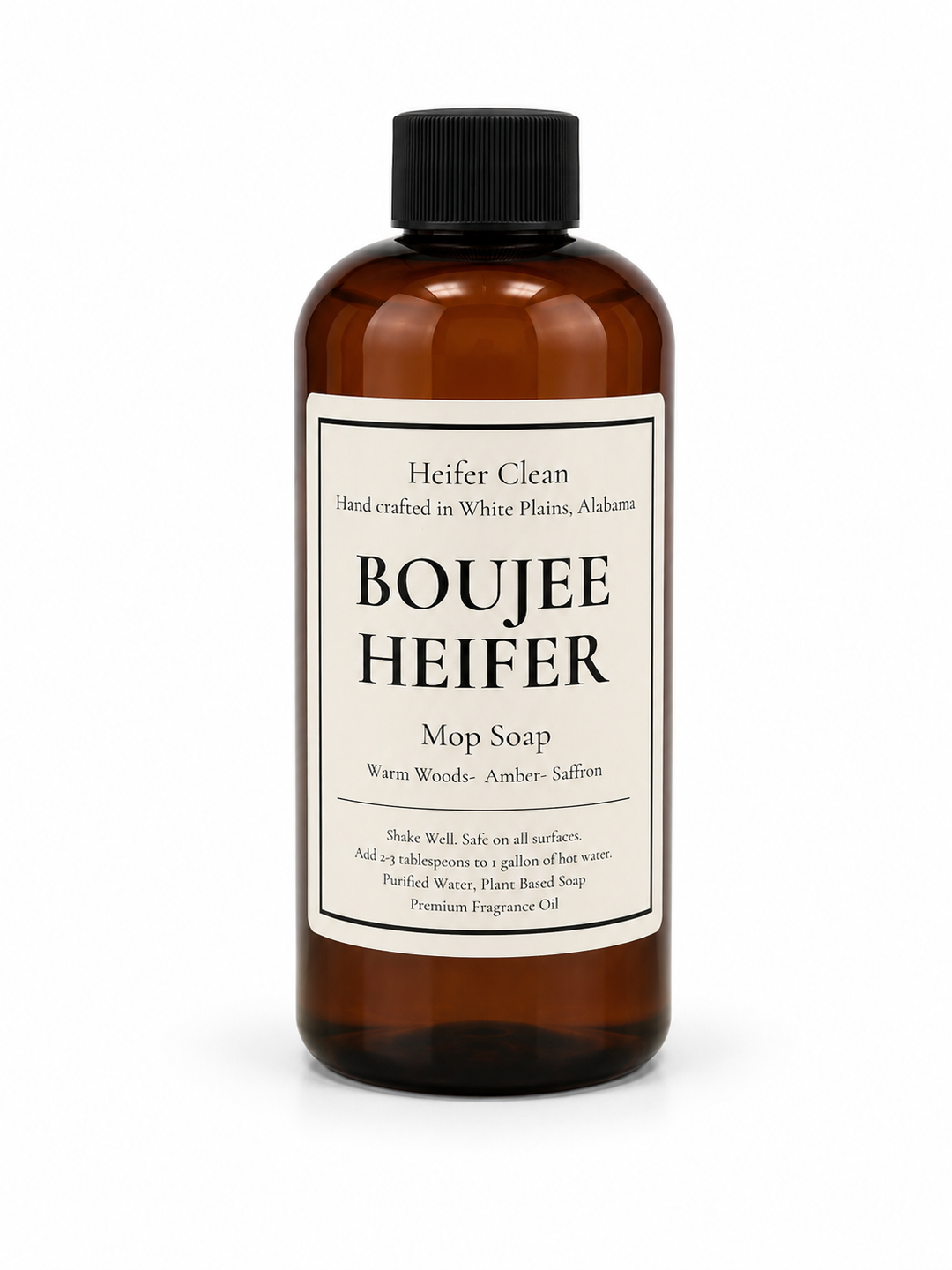 Heifer Clean Boujee Heifer scented mop soap in an amber bottle featuring warm woods, amber, and saffron fragrance for cleaning all hard floor surfaces.