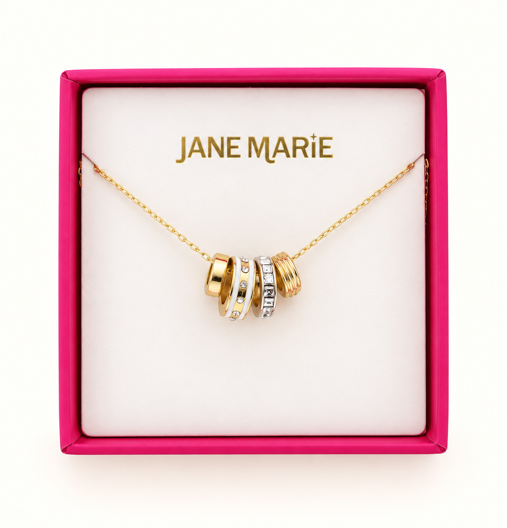 Jane Marie gold cable chain necklace featuring crystal and white rondelle pendant accents displayed in a pink jewelry gift box with branded insert.