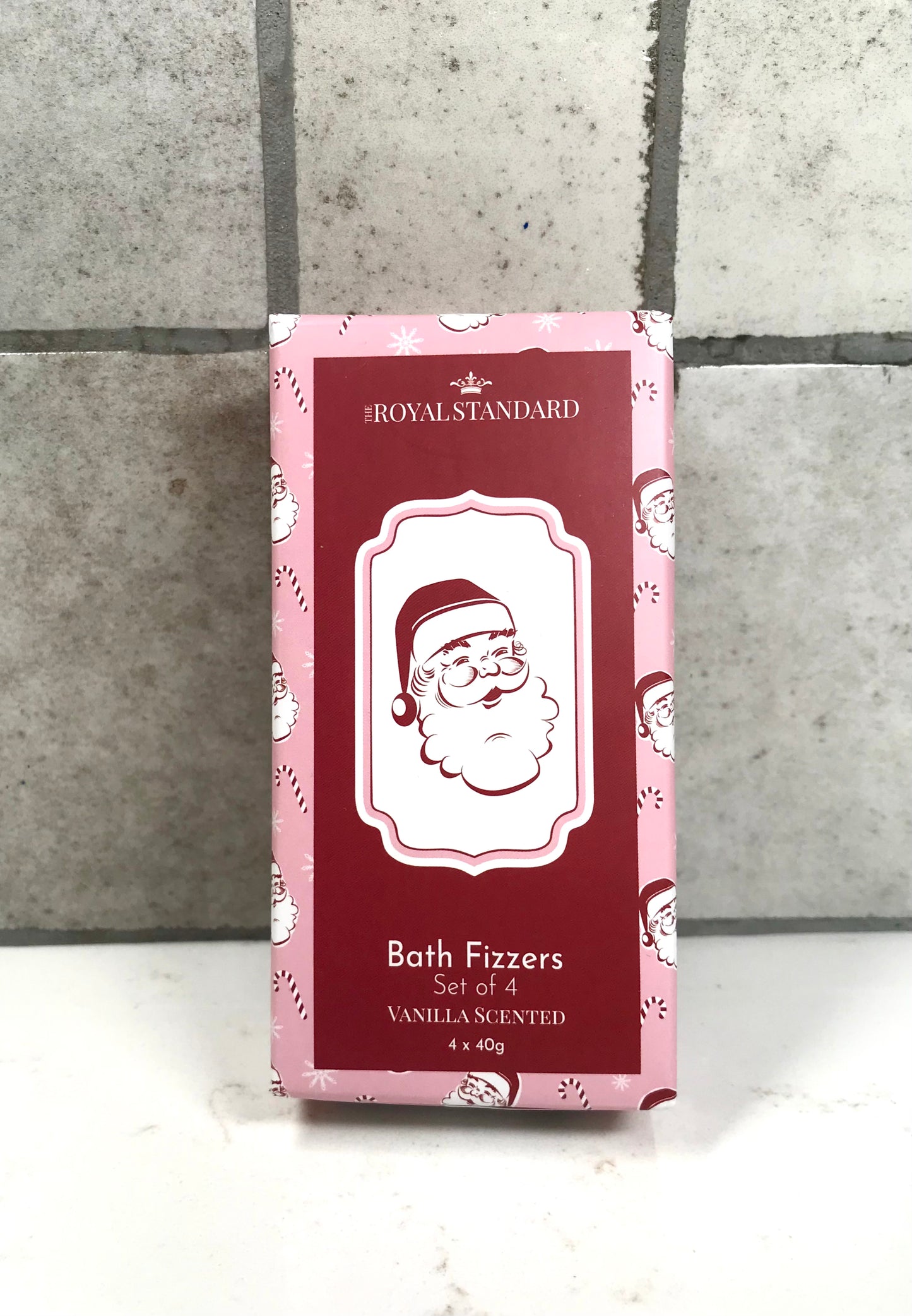 Box of bath fizzers with Santa Claus design on a tiled wall background